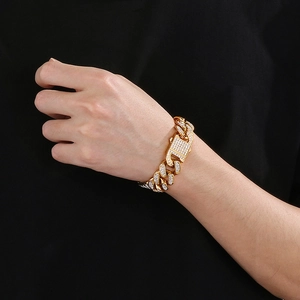 Close-up of gold iced-out Cuban link bracelet with pavé rhinestones on model's wrist