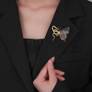 Exotic snake and butterfly brooch with gold metal and purple embroidery on a black blazer