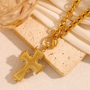 Macro shot of vintage 18K gold plated stainless steel cross pendant with OT clasp