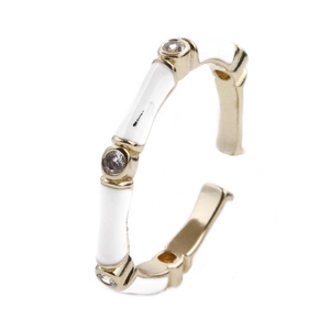 Detail of adjustable gold bamboo ring with white enamel and sparkling zircon accents