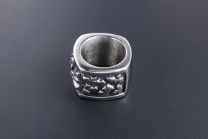 Macro side view of heavy titanium steel wide band ring with irregular embossed texture