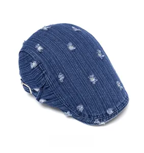 Top view of deep blue washed denim beret featuring distressed details and metal buckle