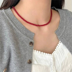 Close-up of elegant red agate beaded necklace on collarbone with delicate glossy beads