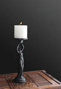 Detailed view of black cast iron angel candle holder with textured matte finish
