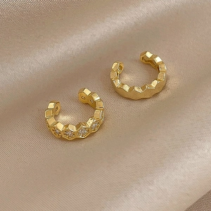Golden honeycomb ear cuffs with white zircon on champagne silk background