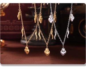 Detail showing heart and horn pendants on 18K gold and silver stainless steel necklaces