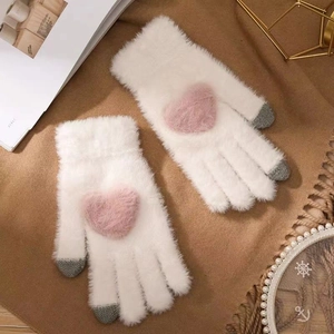 Detailed view of white faux mink gloves with pink heart pattern and gray touchscreen tips