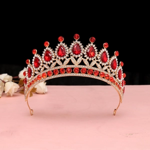 Dettaglio corona dorata vintage con gemme rosse a forma di pera e strass scintillanti