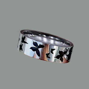 Detailed view of silver titanium steel ring with engraved butterfly pattern and polished finish
