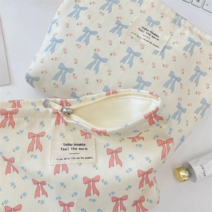 Detailed close-up of floral bow canvas cosmetic pouches with premium metal zippers