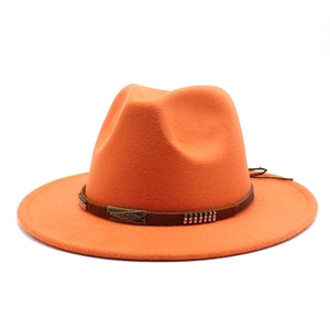 Detail of orange fedora wool hat with brown leather band and metallic G emblem