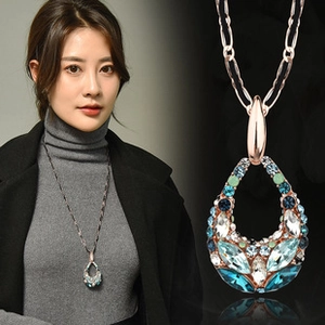 Detail of rose gold teardrop pendant with multi-colored crystals on a long chain