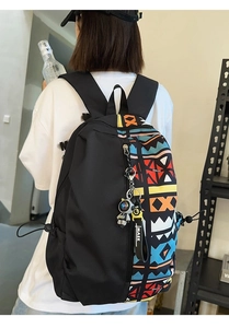 Detail of black backpack with geometric patterns and astronaut charm on a model