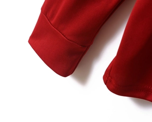 Detailed close-up of red polo shirt featuring piqué knit fabric texture and seam stitching