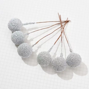 Detail of silver textured Christmas berries on brown wire stems for festive DIY crafts