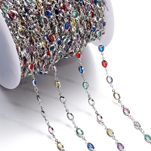 Detailed macro view of colorful oval crystal chain links in silver metal frames for DIY