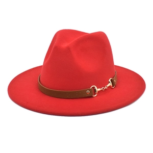 Close-up of red wide brim fedora with brown belt and golden horsebit metal buckle