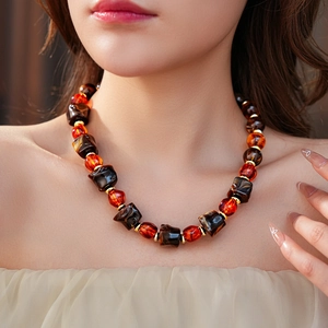 Close-up of irregular tortoiseshell beads necklace with gold spacers on model