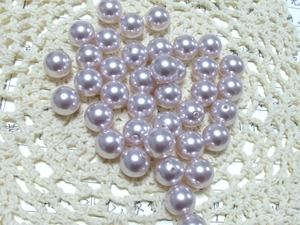 Macro shot of pale lavender round loose pearls with pre-drilled holes for DIY jewelry