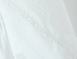 Detailed macro view showing stitching craft and fabric texture of white lace set