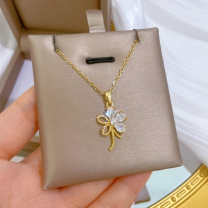 Detailaufnahme der goldenen Halskette mit Kleeblatt-Anhänger und klaren Zirkon-Kristallen