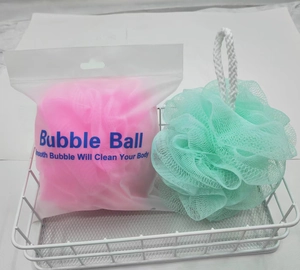 Detail of pink and green mesh bath sponges in a white metal basket with hanging ropes