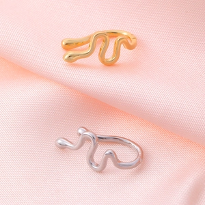 Detailed view of snake-shaped gold and silver non-pierced clips on pink silk fabric