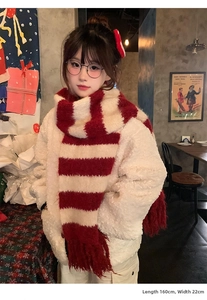Detail view of red and white striped knit scarf with tassels, size 160cm x 22cm