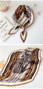Detail of pleated silk scarf with brown leopard print and floral pattern on white background