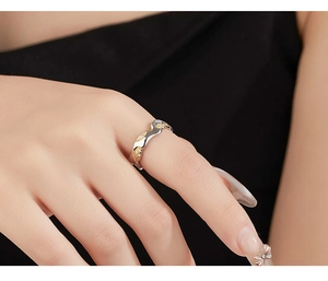 Detail of 925 sterling silver wavy ring with gold accents and sparkling zircons