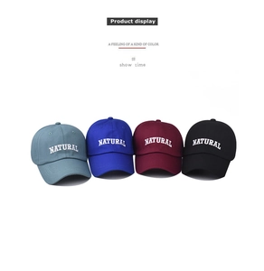Detail of embroidered NATURAL lettering on cotton twill baseball caps in four colors