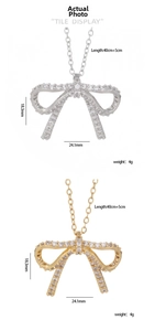 Detailed tile display of bow pendant necklaces in silver and gold with cubic zirconia