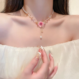 Detail of pink flower pendant necklace with champagne crystal beads and pearl tassels