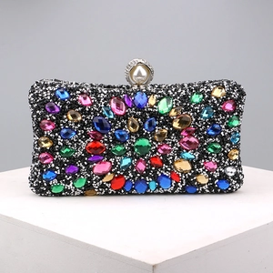 Macro shot of colorful rhinestones and faux pearl clasp on a black luxury evening clutch