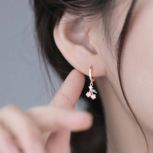 Sweet pink cherry drop hoop earrings in rose gold finish worn by model close-up