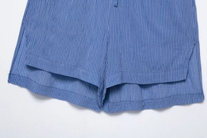 Détail de la fente latérale sur le short à fines rayures bleu marine et coutures