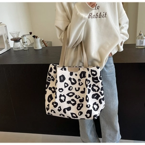 Détail du grand sac cabas en toile à motif léopard avec des anses kaki sur un mannequin