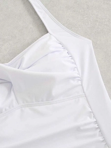 Close-up of white swimsuit featuring pleated texture and reinforced double stitching