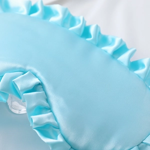 Light blue faux silk sleep eye mask with elegant ruffled edges and smooth satin texture