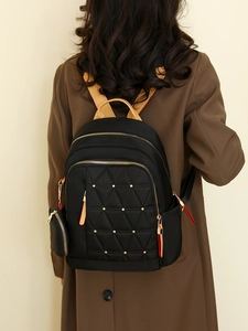 Mochila de mujer en tela oxford negra con acolchado de rombos y tachuelas doradas