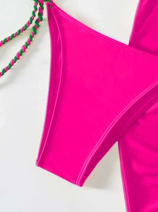 Detail of vibrant fuchsia bikini bottom with green braided tie strings for swimwear