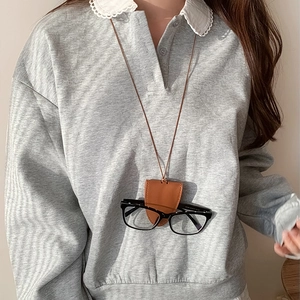 Brown leather glasses holder necklace showing close-up stitching and clip-on detail