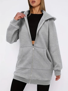 Detail view of grey oversized zip-up hoodie featuring a large pocket and soft fabric texture