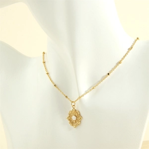 Detail of vintage 18K gold plated oval filigree pendant necklace with white stone center