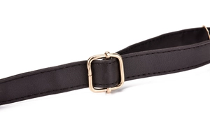 Detail of black leather shoulder strap with gold buckle and neat stitching work