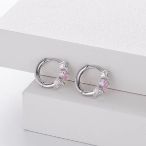 Detailed macro view of 925 silver hoop earrings with pink and clear heart zircons