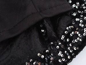 Close-up of black sequined dress showing detailed stitching and fabric texture