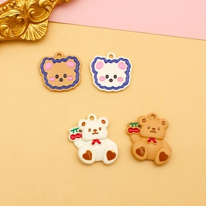 Detail view of cute bear resin charms with cherry accents for DIY jewelry and hair accessories