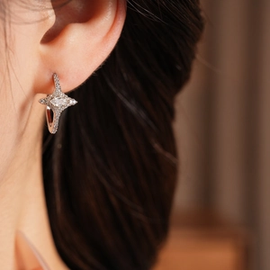 Close-up of silver star earrings with sparkling cubic zirconia on a female model
