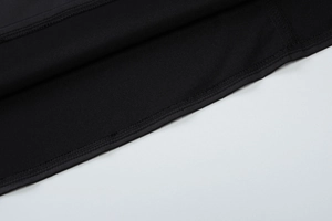 Detailed view of the hem stitching on a black fabric backless halter neck dress